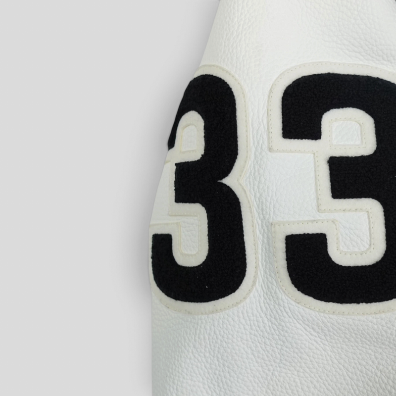 CLB XXIII white leather sleeve detail from a Chrome Hearts varsity jacket featuring a large black felt number 33 patch