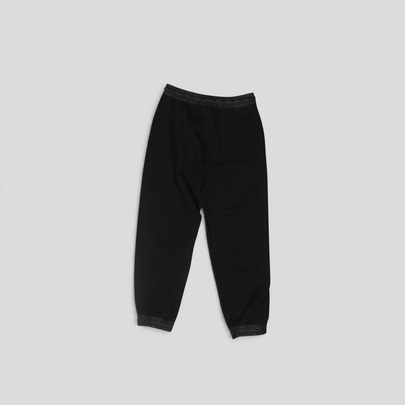 CLB XXIII black cotton technical pants with Louis Vuitton monogram hem detailing, back view.