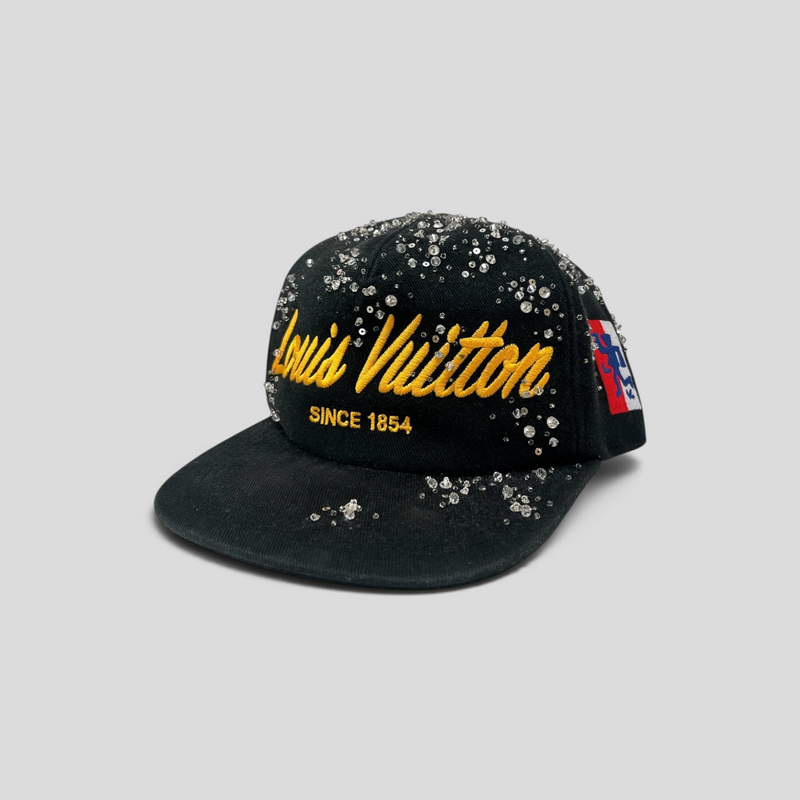 CLB XXIII Louis Vuitton black baseball cap featuring yellow script embroidery, crystal embellishments, and side patch