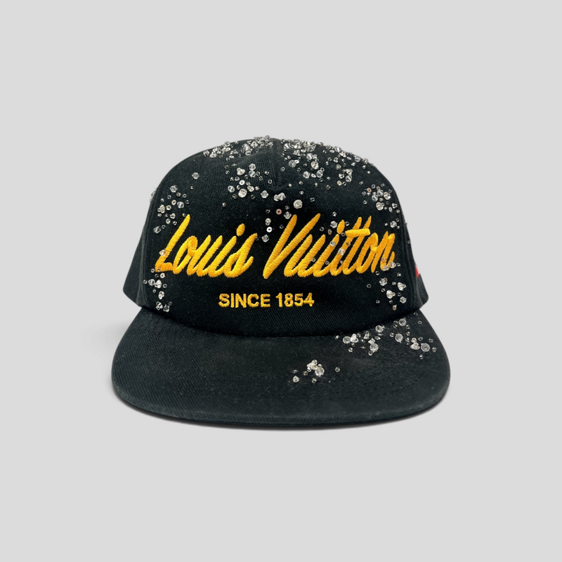 CLB XXIII black Louis Vuitton baseball cap featuring yellow script embroidery and scattered crystal embellishments