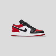 CLB XXIII Air Jordan 1 Low GS Bred Toe sneakers in white, varsity red, and black leather with side swoosh detail.