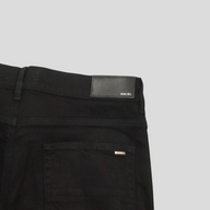 CLB XXIII Amiri black cotton jeans featuring a leather back waist patch and silver logo detail on the back pocket.