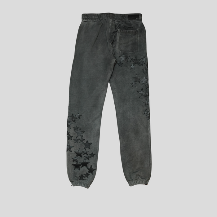 CLB XXIII Amiri grey cotton sweatpants featuring black leather star patches on the legs and a back pocket.