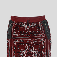 CLB XXIII Amiri red bandana print fleece pants with black leather zippered pockets and an elastic drawstring waist.