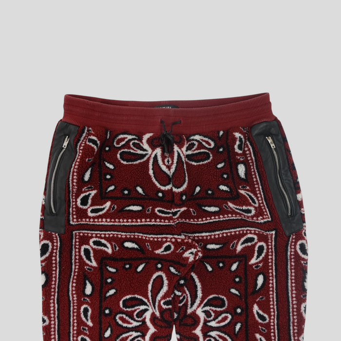 CLB XXIII Amiri red bandana print fleece pants with black leather zippered pockets and an elastic drawstring waist.