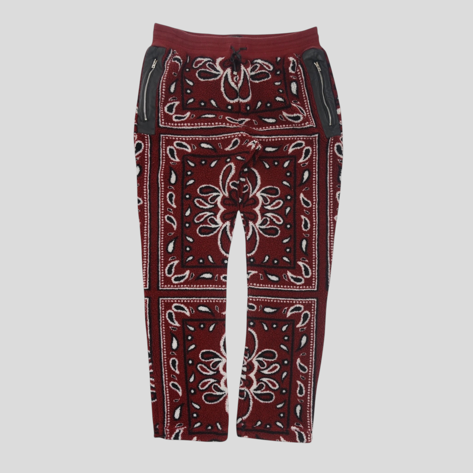 CLB XXIII Amiri red bandana print fleece pants with black leather zippered pockets and an elastic drawstring waist.