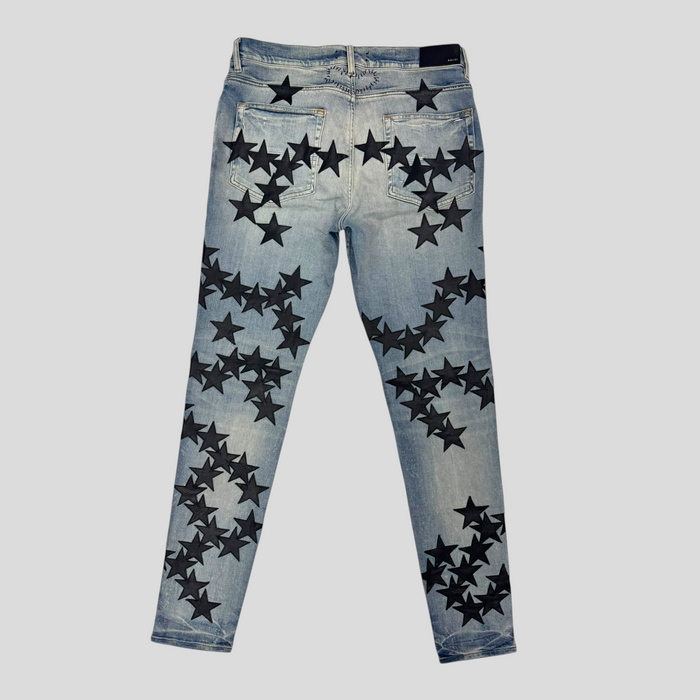 CLB XXIII Amiri Chemist star patch jeans in clay indigo denim with black leather star appliqués, back view.