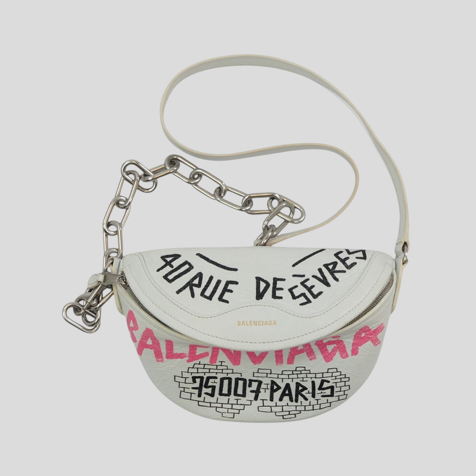 CLB XXIII white leather Balenciaga XS Souvenir belt bag with black and pink graffiti print and silver chain strap.