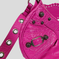 CLB XXIII Balenciaga Le Cagole XS shoulder bag in vibrant pink crocodile-embossed leather with silver metal studs.