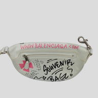 CLB XXIII Balenciaga XS white leather belt bag featuring black and pink graffiti-style souvenir print and zip pocket.