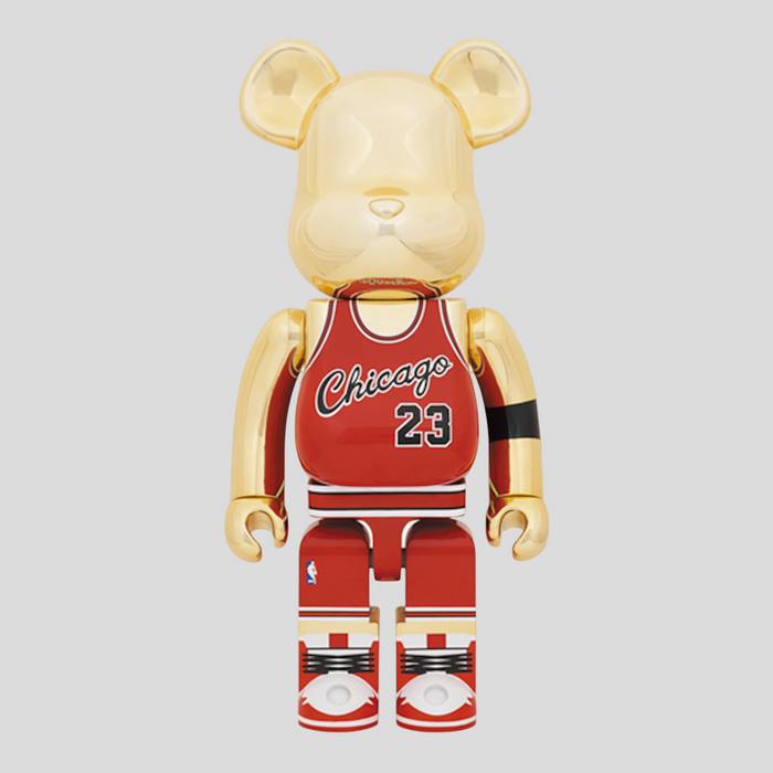 CLB XXIII 1000% Bearbrick Michael Jordan 1985 Rookie Jersey figure in gold and red with Chicago 23 detailing.