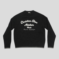 CLB XXIII black virgin wool sweater featuring white Christian Dior Atelier embroidery and ribbed grey hem detail.