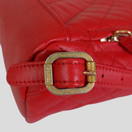 CLB XXIII Chanel red caviar leather filigree backpack featuring a gold-tone buckle detail with quilted texture.