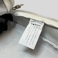 CLB XXIII Chrome Hearts white leather bean bag chair interior tag with silver zipper pull and care instructions