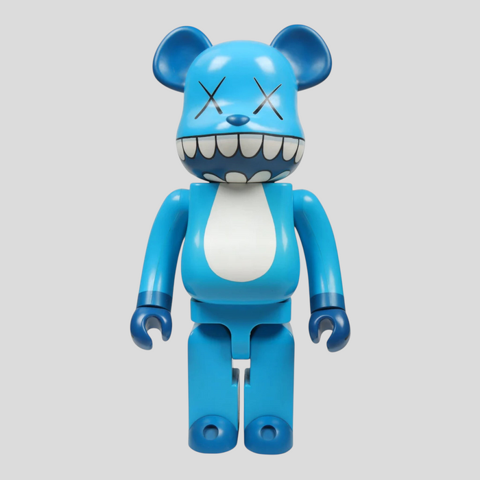 CLB XXIII 1000% Bearbrick Kaws Chomper figure in blue, white, and black with iconic X eyes and wide toothy grin.