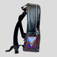 CLB XXIII Louis Vuitton Alps backpack in black Damier Graphite canvas with a colorful V logo patch, side view.