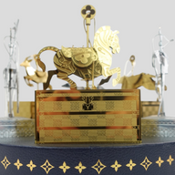 CLB XXIII Louis Vuitton gold-tone metal carousel holiday ornament set featuring a miniature trunk and horse