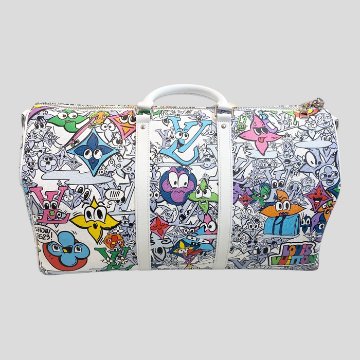 CLB XXIII Louis Vuitton Keepall Bandoulière 50 travel bag featuring a vibrant white graffiti comics print.