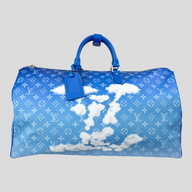 CLB XXIII Louis Vuitton Keepall Bandouliere 50 travel bag in blue Monogram canvas with white cloud print and handles.