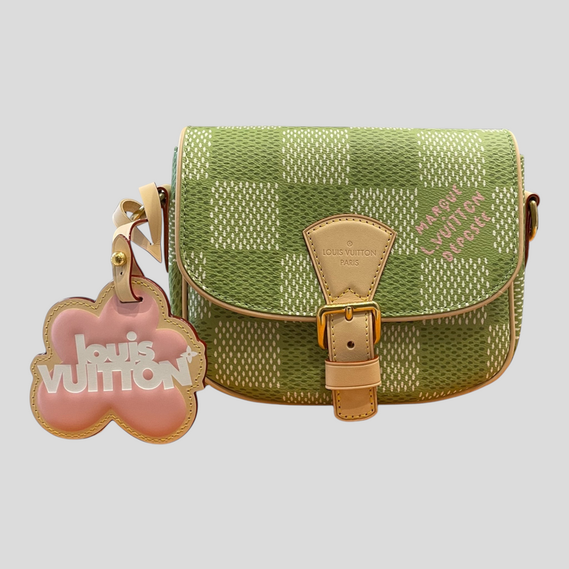 CLB XXIII Louis Vuitton Montsouris messenger bag in golf green Damier canvas with a pink flower-shaped bag charm.