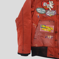 CLB XXIII red Carhartt work jacket featuring patchwork designs, distressed details, and paint splatter accents.