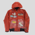 CLB XXIII red Carhartt work jacket featuring patchwork designs, distressed paint splatters, and a hooded silhouette.